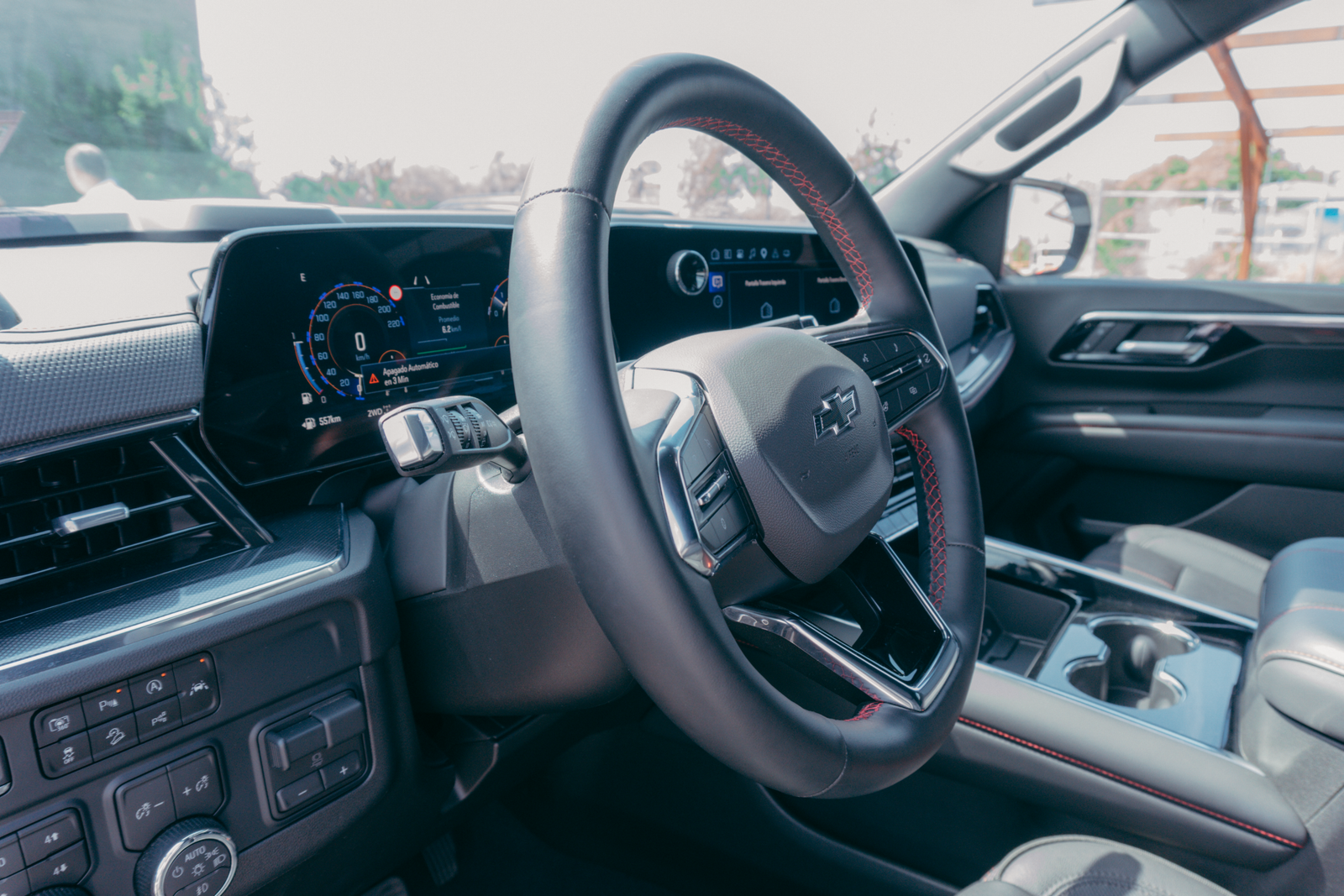Close-up view of a modern car's steering wheel and dashboard displaying advanced technology.